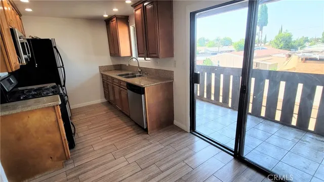 a kitchen with sink a refrigerator and wooden floor