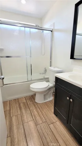 a bathroom with a sink a toilet a mirror and shower