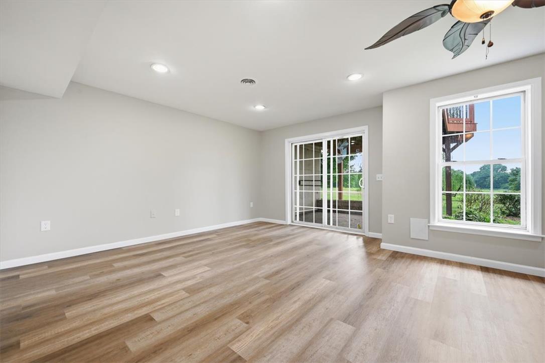 8761 Cascade Road Breinigsville, PA 18031 - Photo 58 of 84 Laminated flooring and recessed lighting grace this versatile room, offering a seamless transition to the outdoors through sliding glass doors.