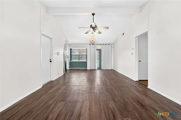 a view of a livingroom with wooden floor and a ceiling fan
