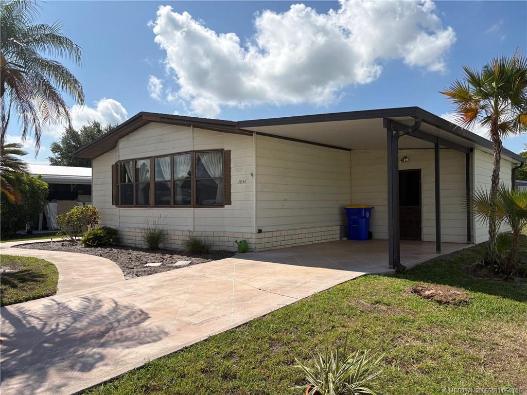 2856 Southwest Toronado Trail Stuart, FL 34997 - Photo 3 of 20 a front view of a house with a yard and garage