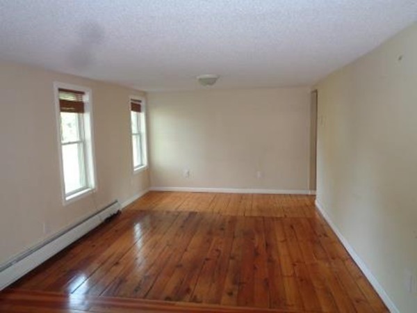 113 Bourne Street Three Rivers, MA 01080 - Photo 5 of 19 an empty room with wooden floor and windows