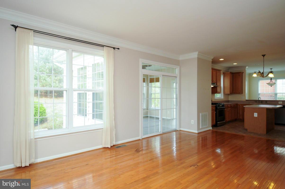 17616 Overlook Road Dumfries, VA 22026 - Photo 11 of 30 a view of a kitchen with kitchen island a sink wooden floor and a large window