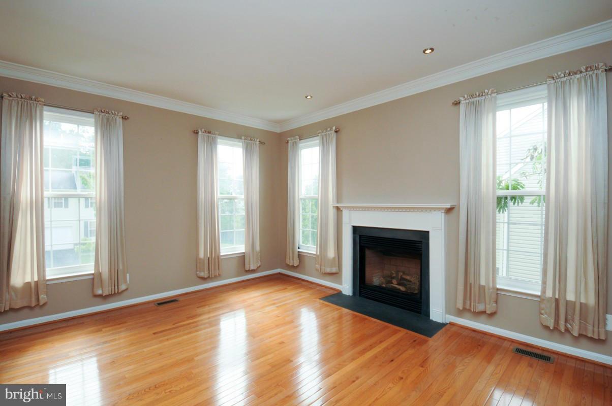 17616 Overlook Road Dumfries, VA 22026 - Photo 6 of 30 a view of an empty room with wooden floor fireplace and a window