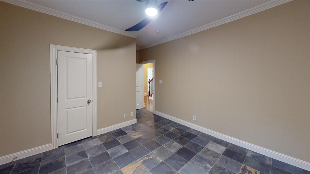 4516 Gilbert Avenue Dallas, TX 75219 - Photo 13 of 28 Spacious room featuring slate-look tile flooring, neutral wall paint, and white trim