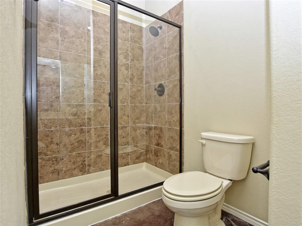515 Jack Rabbit Lane, Unit A Buda, TX 78610 - Photo 11 of 16 a white toilet sitting next to a bathroom sink