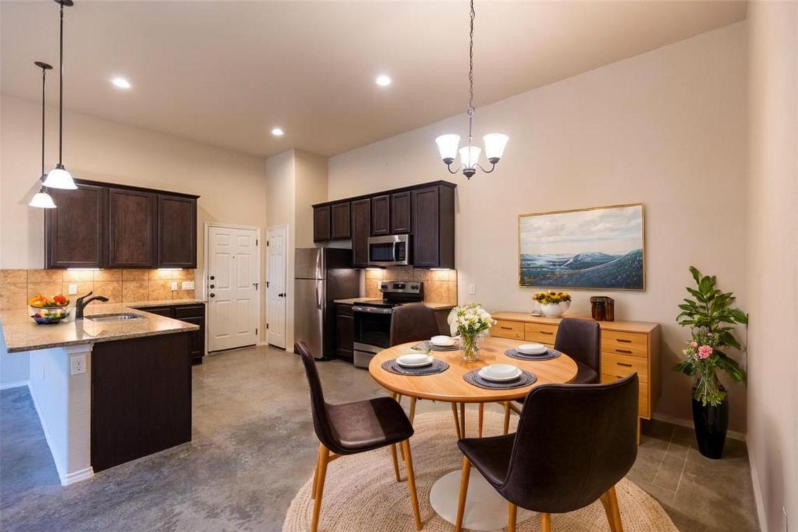 515 Jack Rabbit Lane, Unit A Buda, TX 78610 - Photo 2 of 16 a kitchen with a dining table and chairs