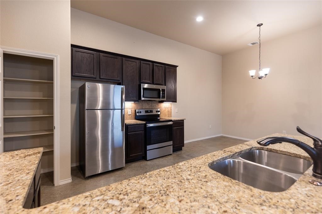 515 Jack Rabbit Lane, Unit A Buda, TX 78610 - Photo 3 of 16 a kitchen with a refrigerator sink and microwave