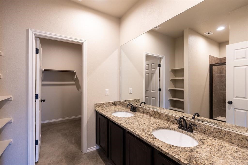 515 Jack Rabbit Lane, Unit A Buda, TX 78610 - Photo 9 of 16 a bathroom with a granite countertop sink and a mirror