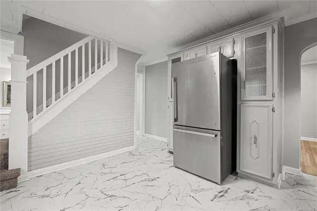 a view of a refrigerator in kitchen and an empty room