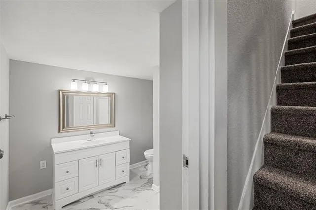 a bathroom with a toilet sink and mirror