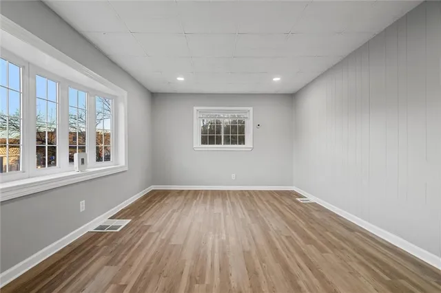 a view of a room with wooden floor and windows