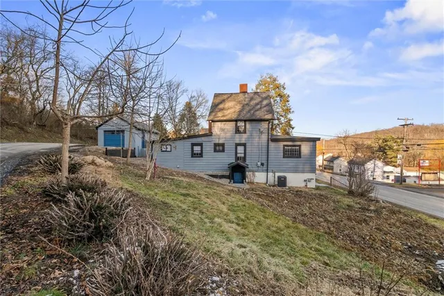 a view of a house with a yard and large tree
