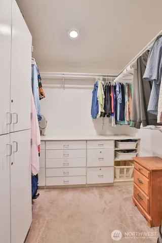 a view of walk in closet with clothes and shoes
