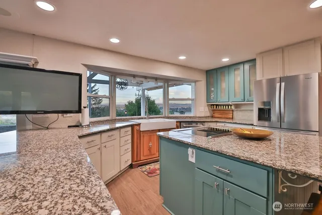 a kitchen with stainless steel appliances granite countertop sink stove and refrigerator