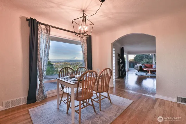 a dining room with furniture wooden floor a rug and a chandelier