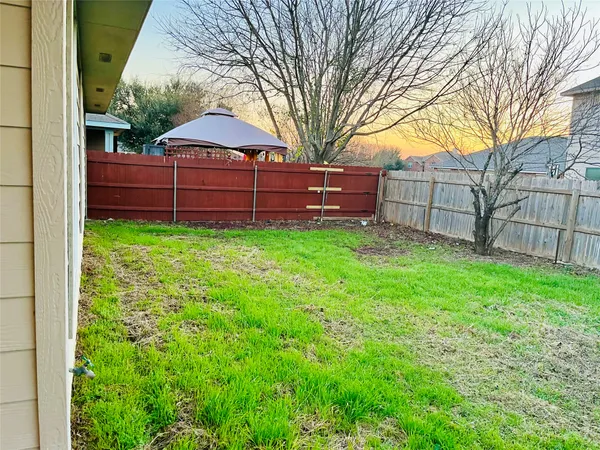 a view of a backyard with a garden and trees
