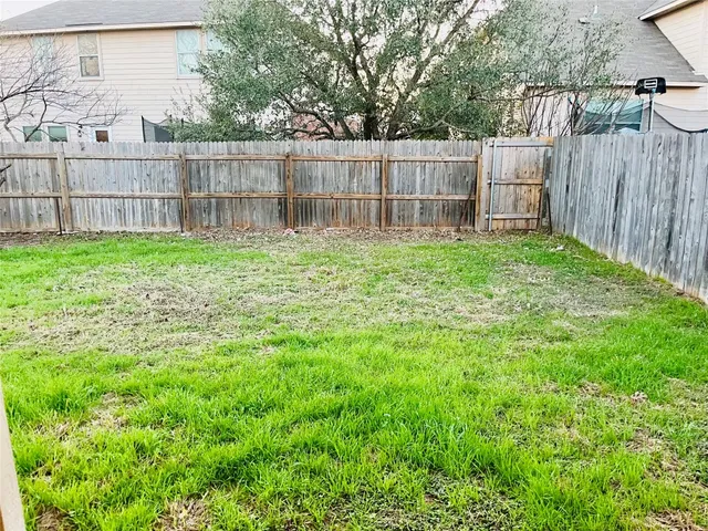 a view of a backyard with a wooden fence