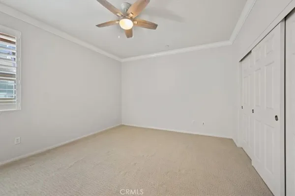 an empty room with a window and a fan
