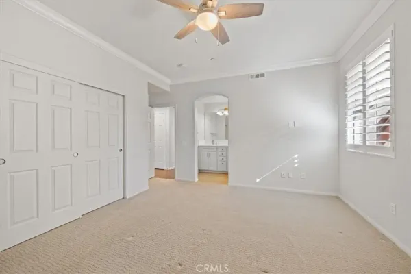 an empty room with windows and fan