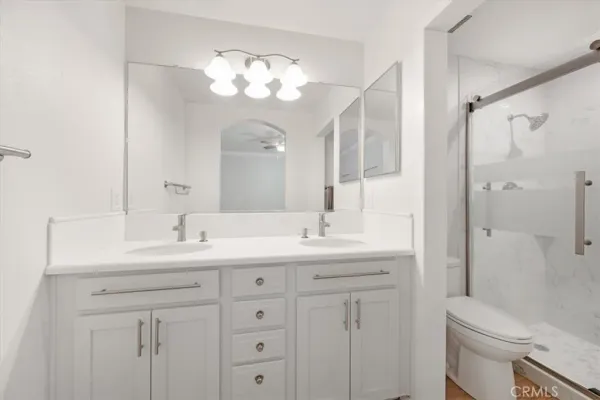 a bathroom with a sink a toilet and a large mirror