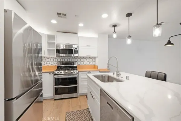 a kitchen with kitchen island a sink stainless steel appliances and cabinets