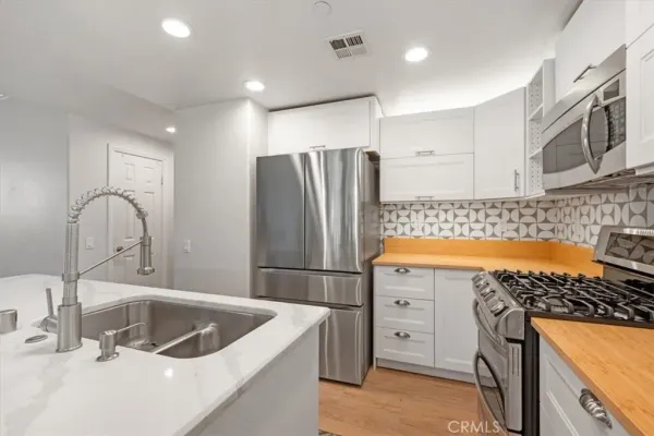 a kitchen with stainless steel appliances granite countertop a sink stove and refrigerator