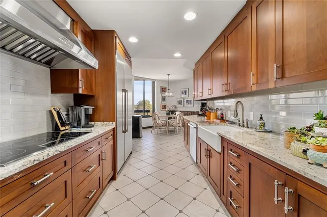 a large kitchen with stainless steel appliances granite countertop a sink counter space cabinets and a stove