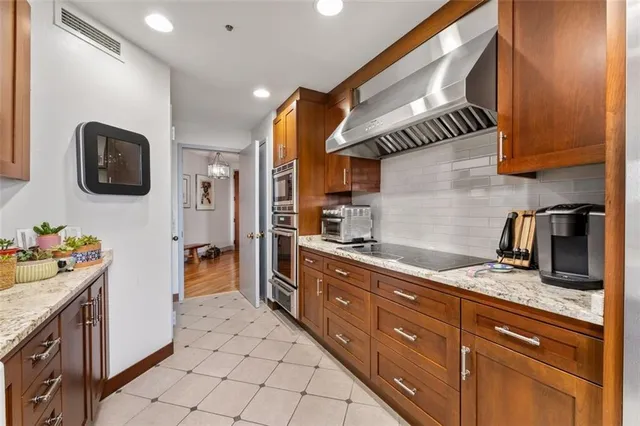 a kitchen with granite countertop a sink a stove and cabinets