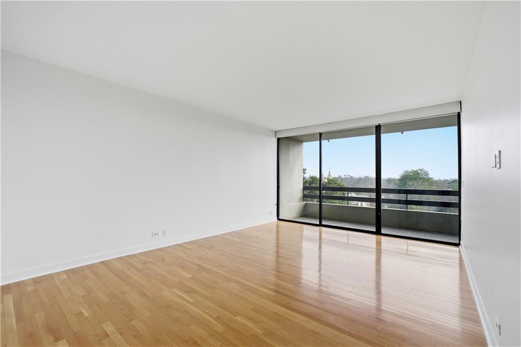 2660 Peachtree Road Northwest, Unit 9G Atlanta, GA 30305 - Photo 16 of 42 a view of an empty room with wooden floor and a window