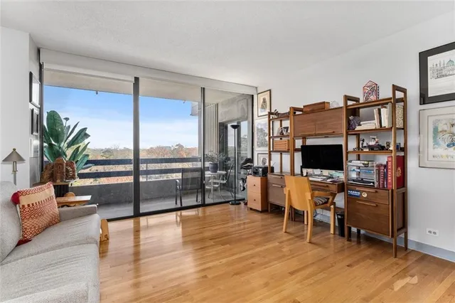 a living room with furniture a flat screen tv and a floor to ceiling window