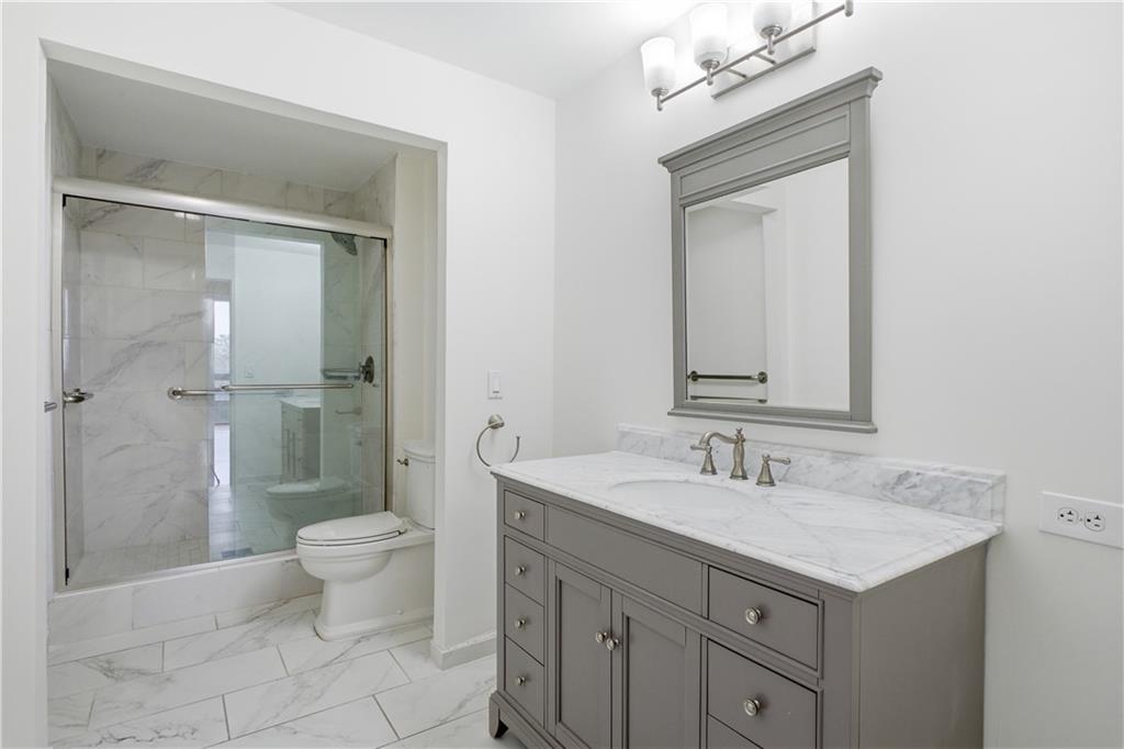 2660 Peachtree Road Northwest, Unit 9G Atlanta, GA 30305 - Photo 19 of 42 a bathroom with a sink a toilet and shower