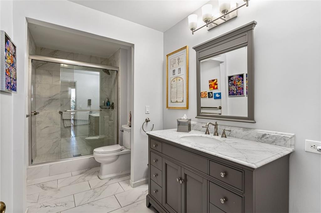 2660 Peachtree Road Northwest, Unit 9G Atlanta, GA 30305 - Photo 20 of 37 a bathroom with a toilet sink and mirror