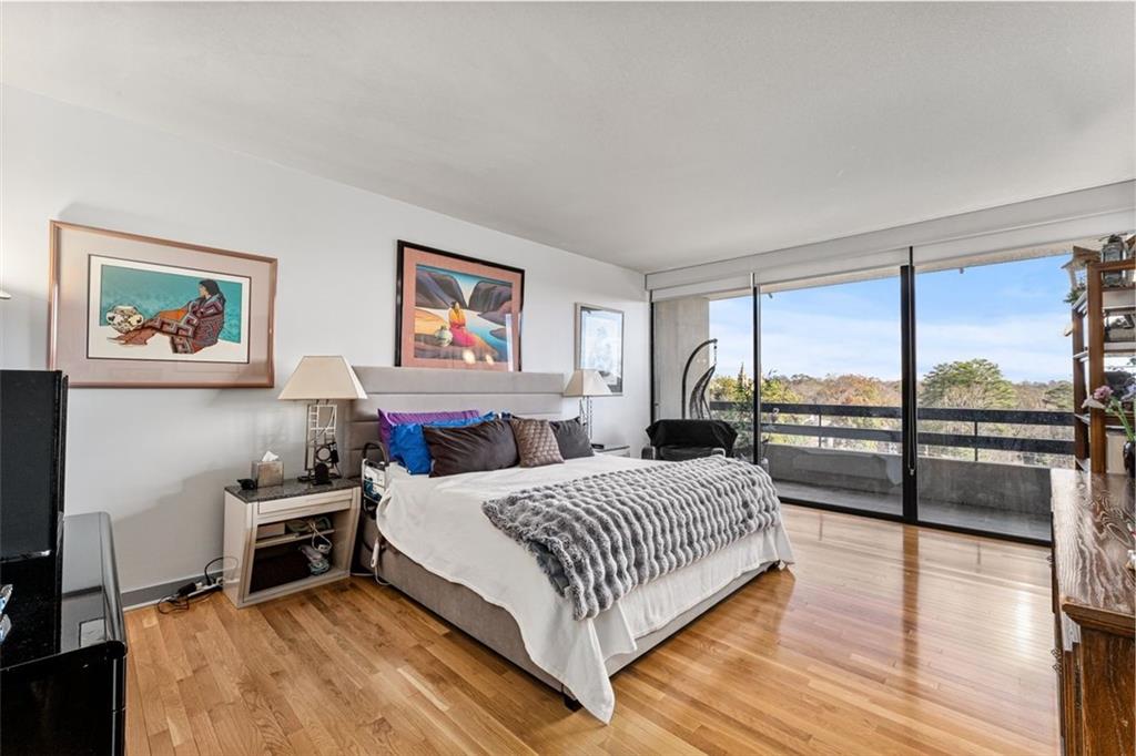 2660 Peachtree Road Northwest, Unit 9G Atlanta, GA 30305 - Photo 24 of 37 a bedroom with a bed and glass walk in closet