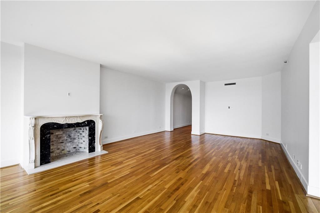 2660 Peachtree Road Northwest, Unit 9G Atlanta, GA 30305 - Photo 6 of 42 a view of an empty room with wooden floor and a fireplace