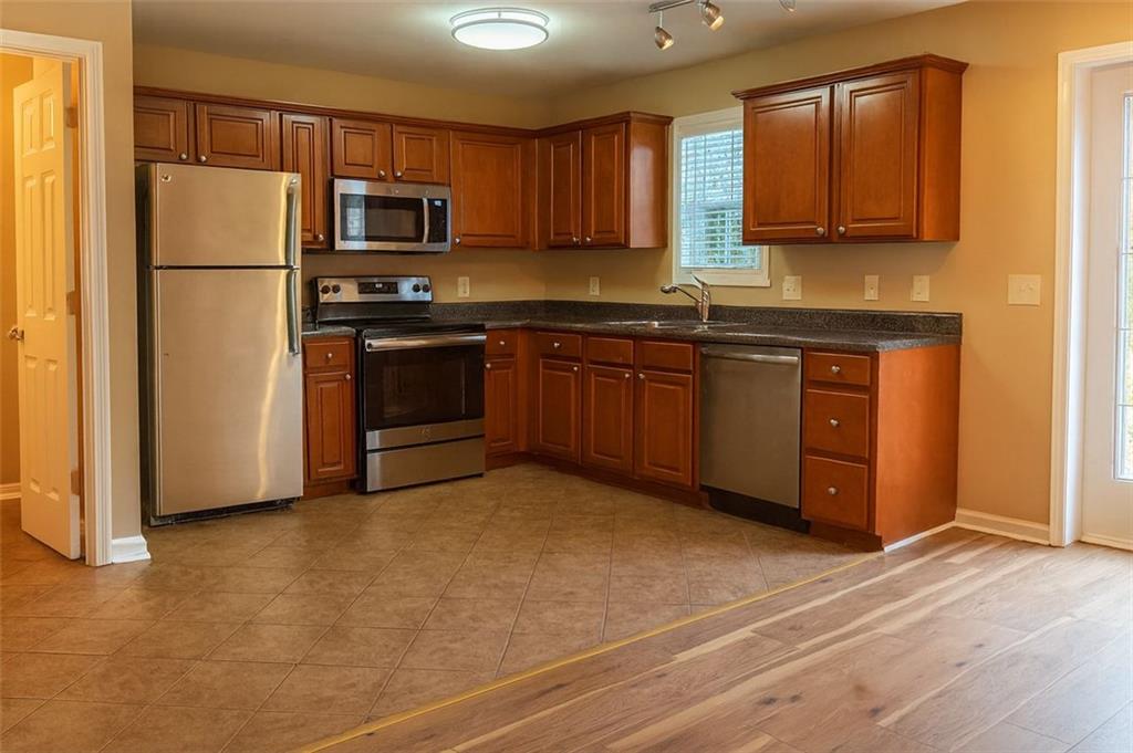 708 Summer Place Northwest Norcross, GA 30071 - Photo 2 of 6 a kitchen with granite countertop a refrigerator and a stove top oven