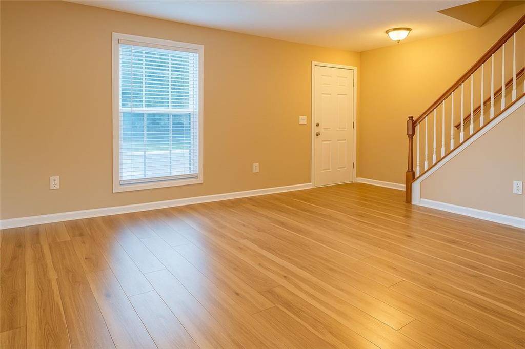 708 Summer Place Northwest Norcross, GA 30071 - Photo 4 of 6 a view of an empty room with wooden floor and a window