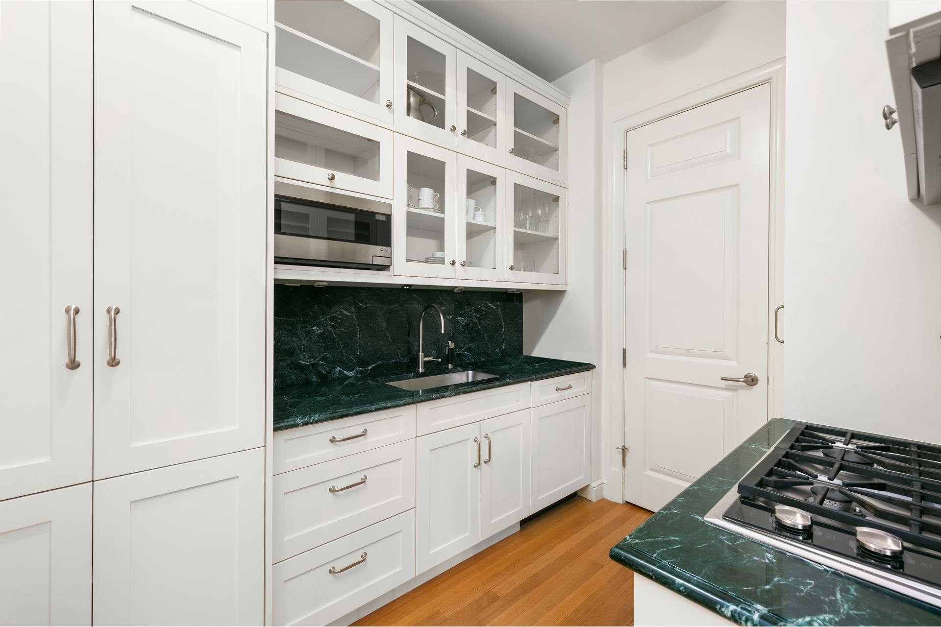 15 Central Park West, Unit 6K Manhattan, NY 10023 - Photo 3 of 13 a kitchen with white cabinets and appliances