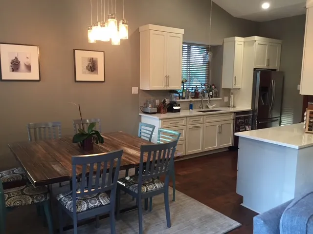 a kitchen with stainless steel appliances a dining table chairs and chandelier