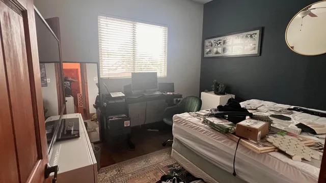 a bedroom with a bed and wooden floor