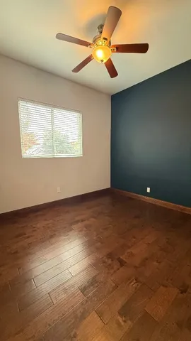 an empty room with a window and a fan