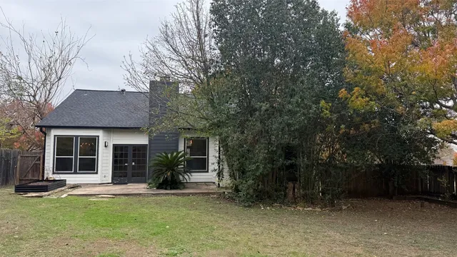 a front view of a house with a garden and trees