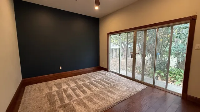 a view of a big room with wooden floor and windows