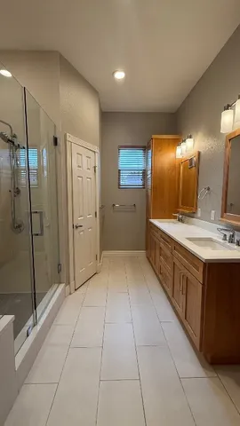 a large bathroom with a glass door shower a sink and a mirror