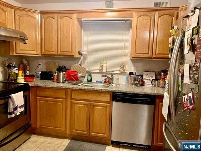 a kitchen with stainless steel appliances granite countertop a sink and cabinets