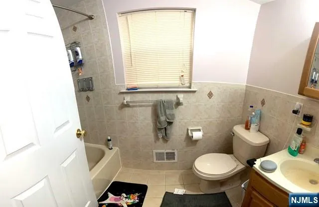 a white toilet sitting next to a bathroom sink and a tub