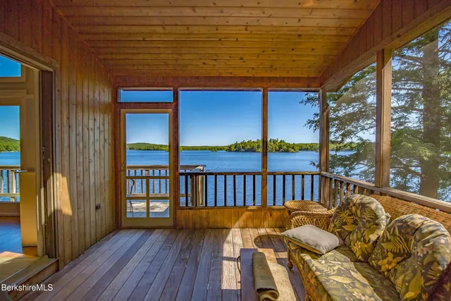 a roof deck with table and chairs and wooden floor