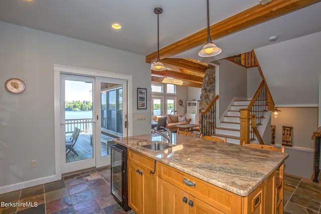 a living room with furniture a rug potted plant and a large window