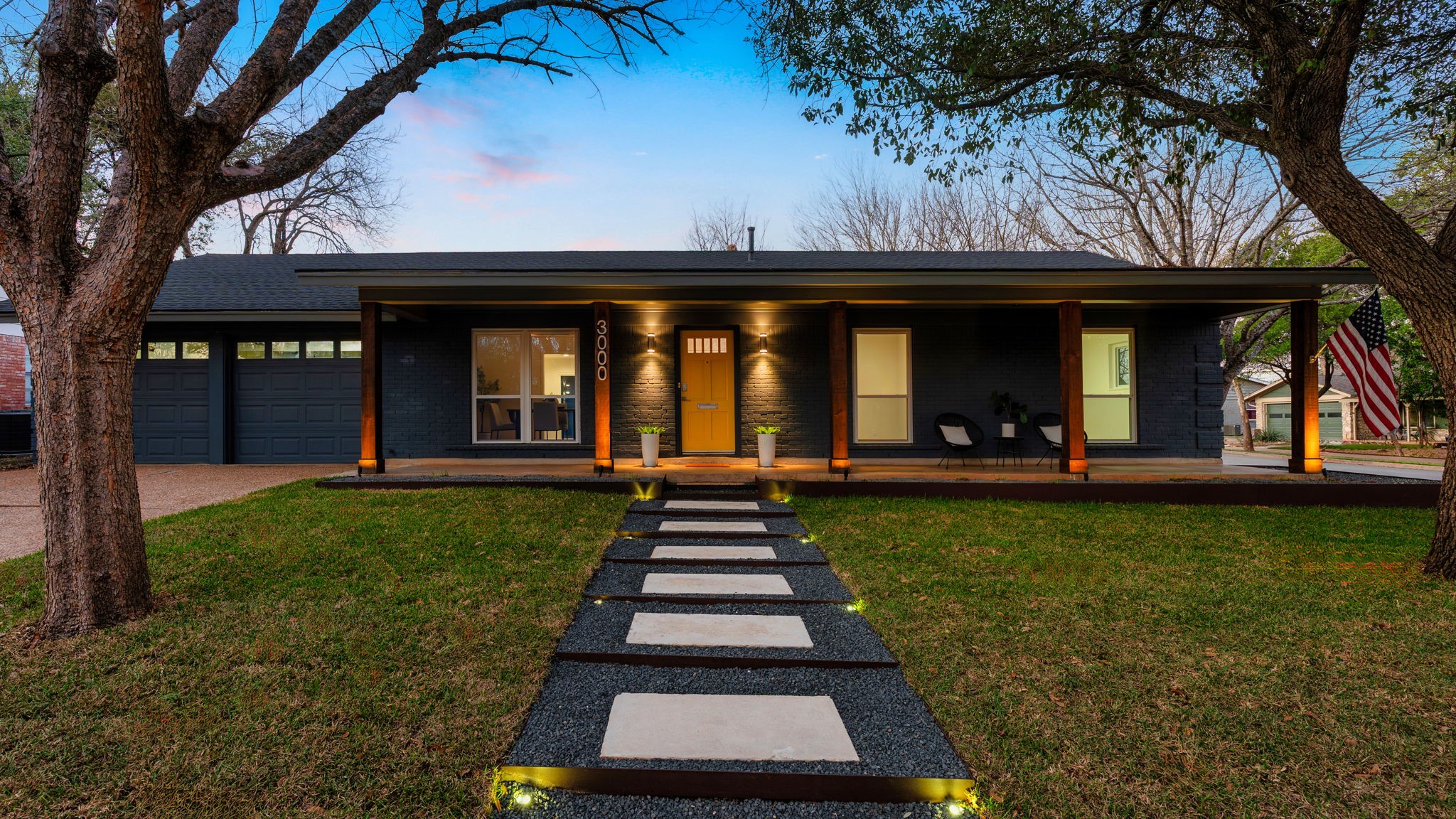 3000 Mohawk Road Austin, TX 78757 - Photo 1 of 1 View of front of home featuring covered porch, a front lawn, a garage, driveway, and brick siding