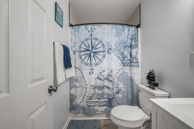 a white toilet sitting next to a shower curtain
